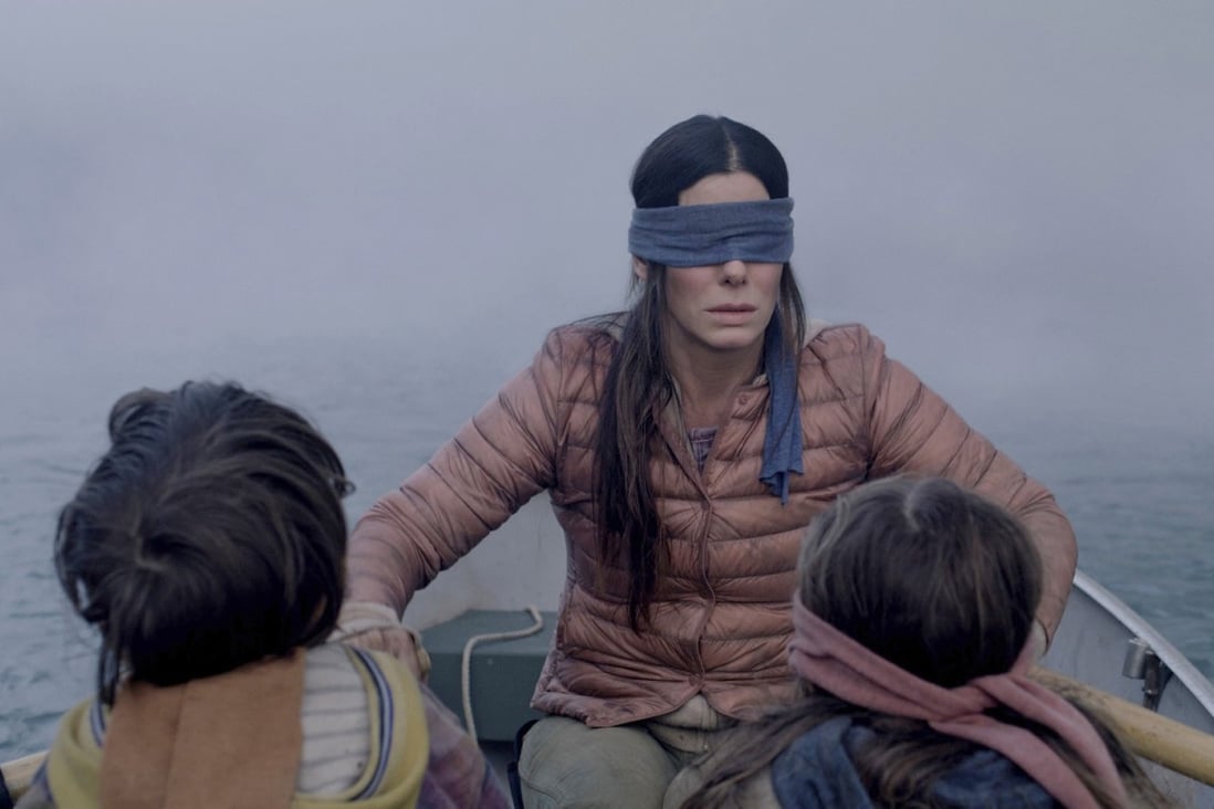 Sandra Bullock plays a woman trying to guide two small children (Julian Edwards, left, and Vivien Lyra Blair) to safety in the post-apocalyptic thriller Bird Box. Photo: Netflix