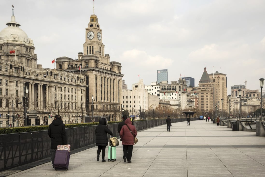 Pedestrians walk along the Bund in Shanghai. How far will China go with its tax cuts? The government announced cuts to personal income tax last year, and the market expects it to unveil a comprehensive tax relief package when the National People’s Congress meets in March. Photo: Bloomberg