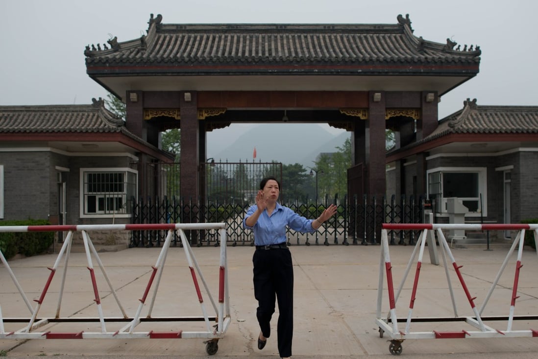 A policewoman tries to stop media from taking photos at the entrance to Qincheng prison. Many of the inmates at the maximum security jail are household names in China. Photo: AFP