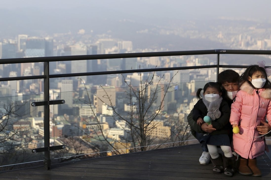 A family wears masks to protect themselves from a thick haze of fine dust in Seoul. Photo: AP