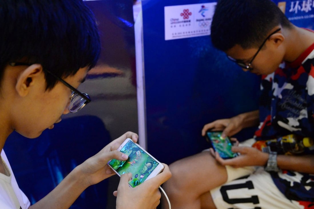 Young boys play games on their smartphones. Photo: CHINA OUT