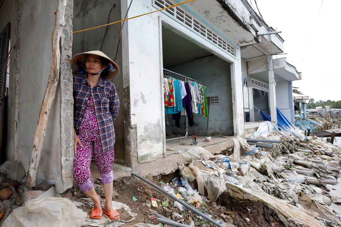 A woman stands at her collapsed house damaged by landslide along Mekong river in Can Tho city, Vietnam. Photo: Reuters