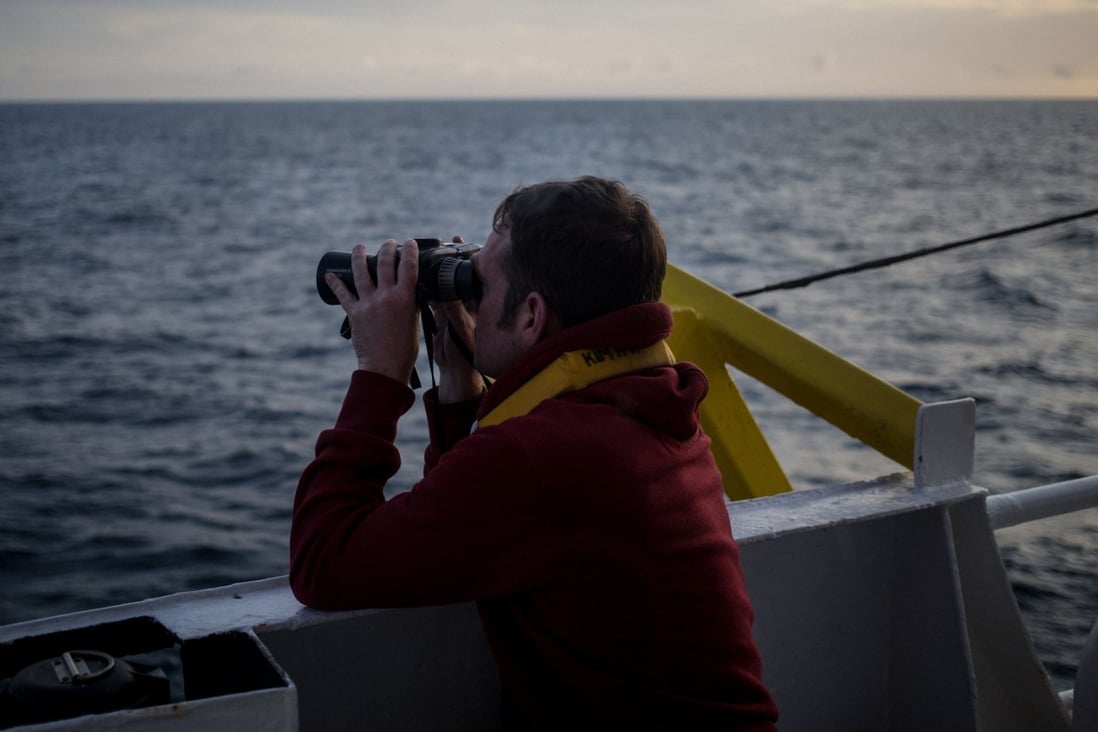 One of the crew members of the Dutch-flagged rescue vessel Sea Watch 3 keeps watch. Photo: AFP