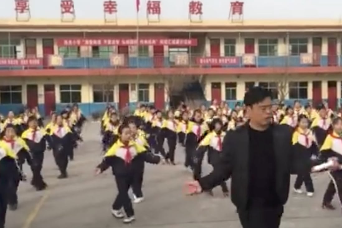 School principal Zhang Pengfei leads the dance routine in front of Xi Guan Primary School. Photo: Handout