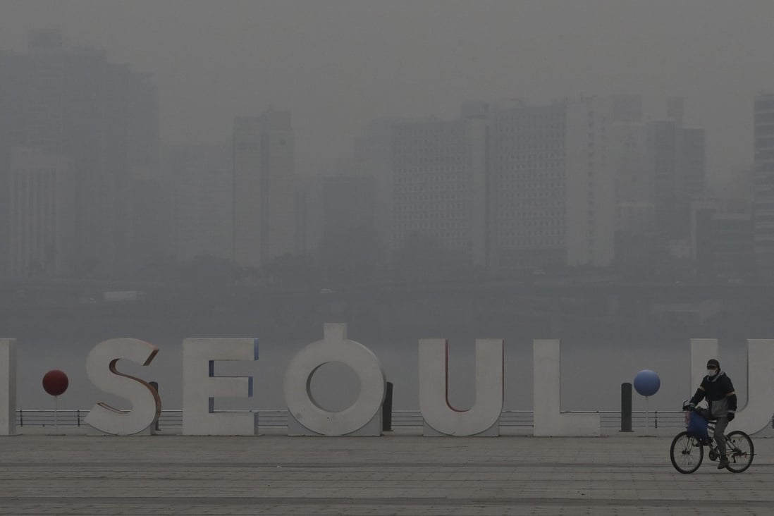 A visitor wearing a mask rides a bicycle along the Han river at a park in Seoul, South Korea. Photo: AP