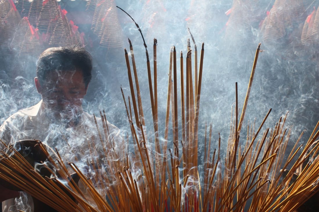 A man burns incense during Tet, the Vietnamese Lunar New Year celebration, in Ho Chi Minh City. Photo: Alamy