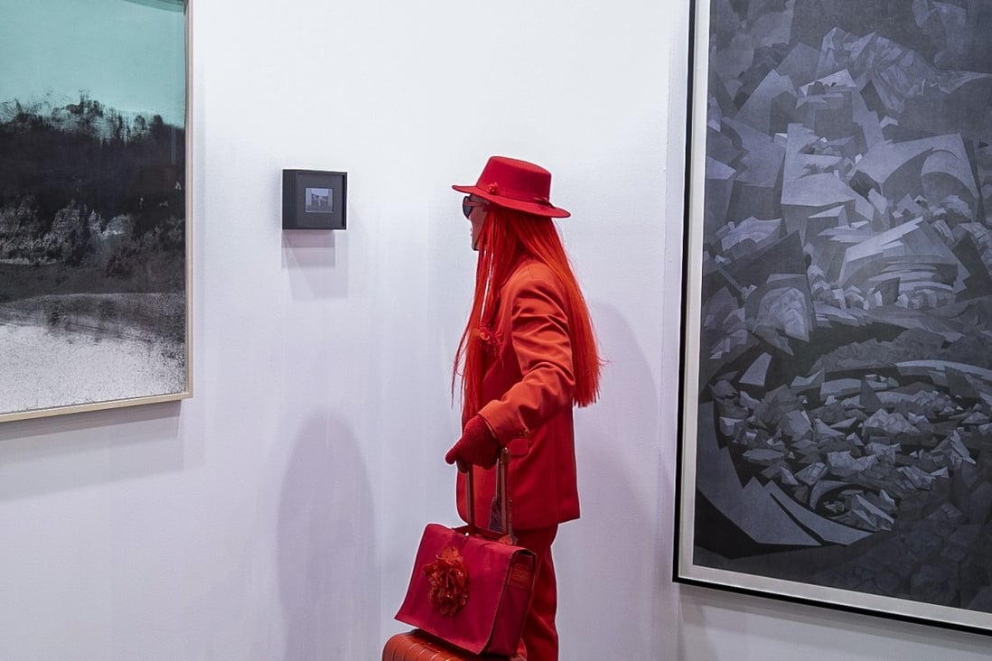 An attendee dressed all in red looks at art on display at the Taipei Dangdai fair in Taipei. Photo: Antony Dickson