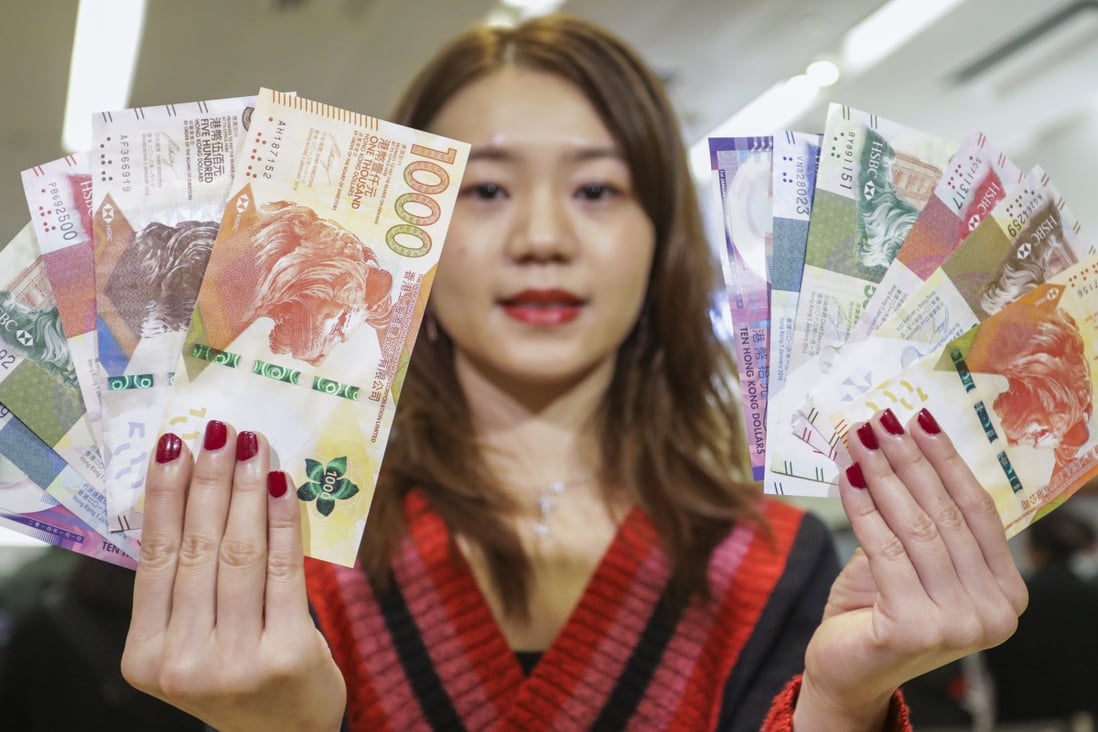 Model poses with new and old banknotes for Lunar New Year red packets at the HSBC branch in Mong Kok. Photo: Tory Ho