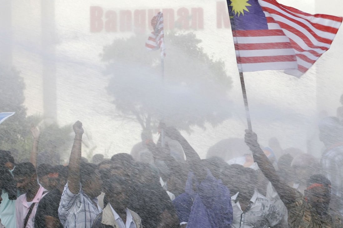 Ethnic Indians are sprayed with water by riot police during a protest in Kuala Lumpur against racial discrimination in 2007, at the time one of the biggest on record. Photo: AP/Vincent Thian