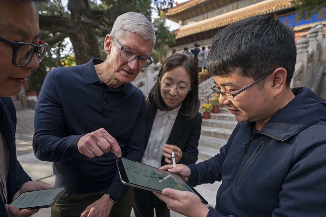 Apple chief executive Tim Cook watches how a person writes calligraphy on an iPad with an Apple Pencil at the Beijing Confucian Temple in the Chinese capital on October 10, 2018. Photo: Xinhua