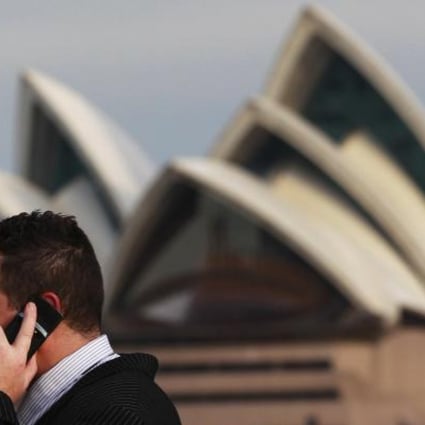 An office worker smokes a cigarette in front of the Sydney Opera House on August 15, 2012. Australia called on the rest of the world to match its tough new anti-tobacco marketing laws after its highest court on Wednesday dismissed a challenge from international cigarette companies in a major test case. REUTERS/Daniel Munoz 