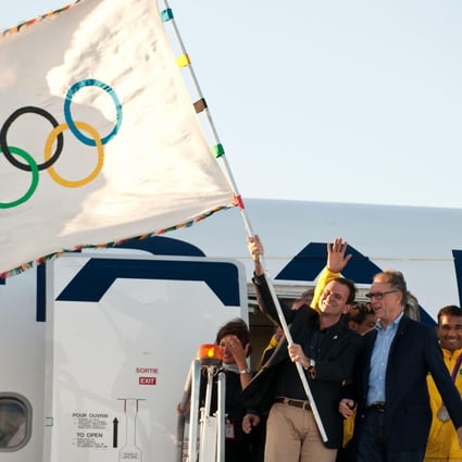 Rio de Janeiro Mayor Eduardo Paes waves the Olympic flag on its arrival in his city on Monday.Photo: Xinhua