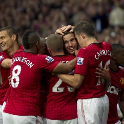 Robin van Persie (centre right) is mobbed by his new teammates after scoring his first goal for Manchester United against Fulham yesterday. Photo: AP
