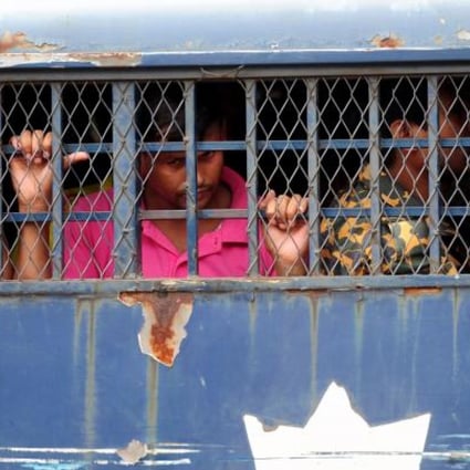 Bangladesh Border Guard soldiers on trial wait in a prison van at at the BDR headquarters in Dhaka. Photo:AFP 