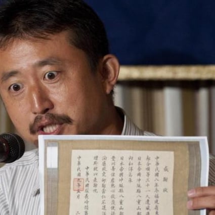 Politician Eiji Kosaka yesterday shows the media a document that he says proves the disputed Diaoyu Islands belong to Japan. Photo: EPA