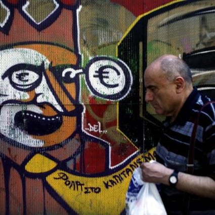 A pedestrian walks past anti-euro-zone graffiti in Athens. But there is more optimism on European company debt. Photo: Bloomberg