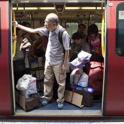 Mainland visitors board a train in Sheung Shui with goods bought in Hong Kong. Photo: EPA
