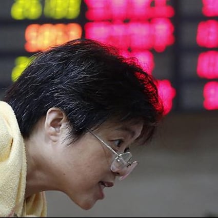 An investor looks at stock prices in Shanghai. Fears of a hard landing in China are casting a pall over stock markets elsewhere in the region, particularly Hong Kong.  Photo: AP