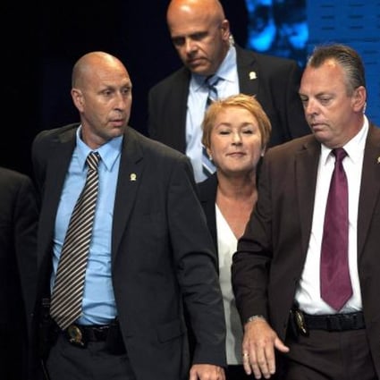 Parti Quebecois leader Pauline Marois (centre) is surrounded by police after shots rang out during her victory speech in Montreal on Wednesday. Photo: AP