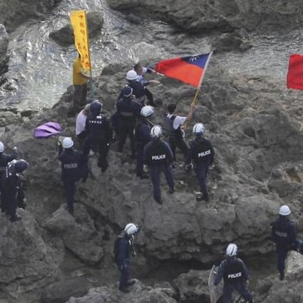 Activists with Chinese and Taiwanese flags are arrested by Japanese police after landing on a disputed island on August 15. Photo: AP