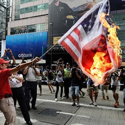 A Hong Kong protester lighted and waved a flag that melded the Japanese and American emblems. He was arrested for disorder in a public place soon after. Photo: AFP