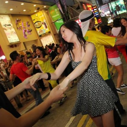 International Zouk Flash Mob members dance outside Fashion Walk - while news footage of riots played on big screens. Photo: Nora Tam