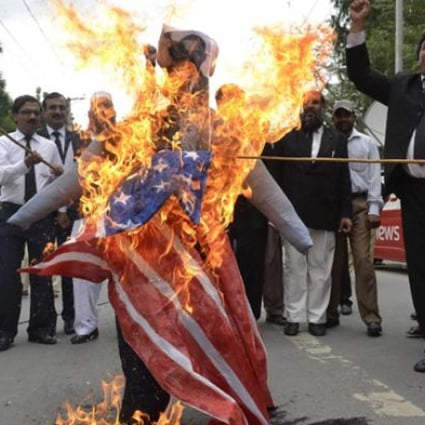 Pakistani lawyers shout slogans as they burn a US flag and an effigy of US President Barack Obama and Florida pastor Terry Jones during a protest in Multan on Monday. Photo: AFP