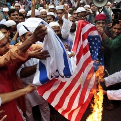 Bangladeshi Muslims burn flags of the US and Israel during a protest in Dhaka on Friday. Photo: AP