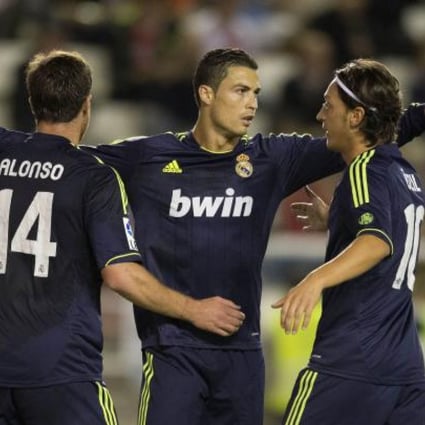 Real Madrid's Cristiano Ronaldo (C) celebrates with team mates Xabi Alonso (L) and Mesut Ozil.  Photo: AFP
