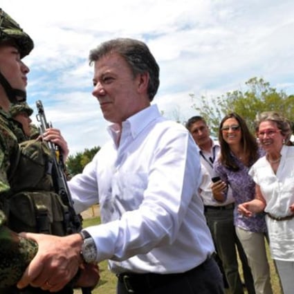 President Juan Manuel Santos (centre) greeting his son Esteban Santos during the delivery of weapons to new soldiers at the Tolemaida Army Base. Photo: AFP