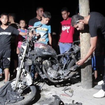 Palestinians inspect a destroyed motorbike following an Israeli aerial bombing in the southern Gaza Strip city of Rafa on Sunday. Photo: Xinhua