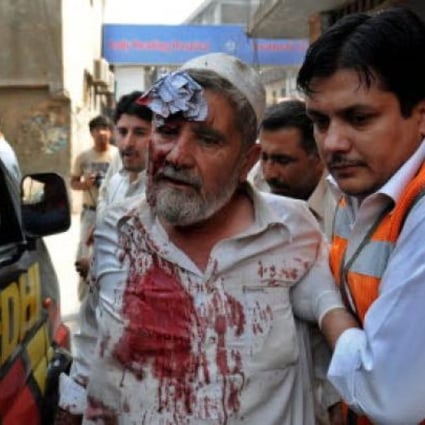 A paramedic helps a victim of a bomb explosion, at a local hospital in Peshawar, Pakistan on Saturday.. At least 15 people were killed in the attack. Photo: EPA