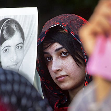 A protester holds up a photo of Malala Yousufzai at a demonstration in Islamabad on Saturday. Photo: AP