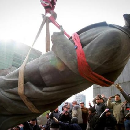 A crowd watches Lenin's statue being taken away. Photo AFP