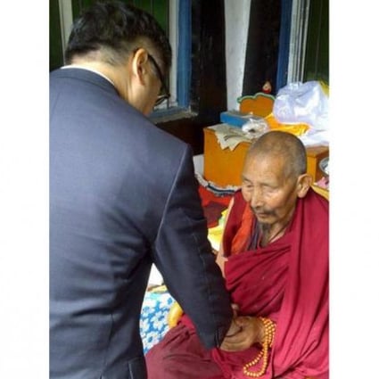 US envoy Gary Locke shakes hands with a Tibetan monk.