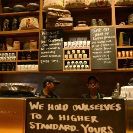 Staff working behind the counter at India's first Starbucks outlet, in Mumbai. Photo: AFP