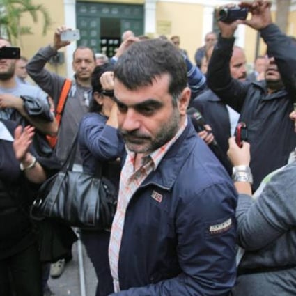 Costas Vaxevanis (centre) Greek journalist and publisher of the magazine <i>Hot Doc</i> exits the prosecutor's office in Athens on Sunday. Photo: EPA