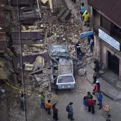 Guatemalans stand among the destruction of the quake. Photo: AP