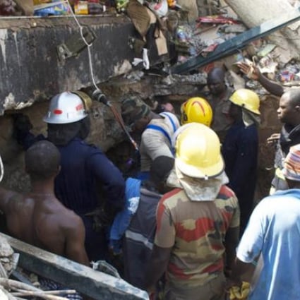 Rescue workers drill into the roof of a collapsed shopping mall that killed at least seven people and trapped dozens of others on Wednesday in Accra. Photo: AFP 