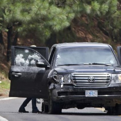 An armoured US embassy vehicle is checked by military personal after it was attacked on the highway leading to the city of Cuernavaca, Mexico. Photo: AP