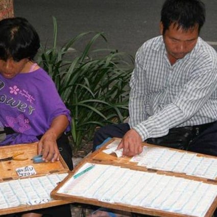 Lottery ticket vendors ply their trade on a Bangkok street.