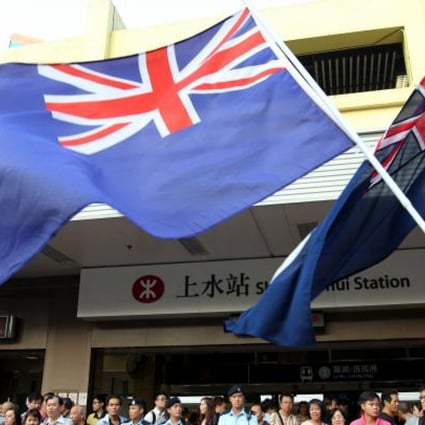Protestors of Reclaim Sheung Shui wave Hong Kong Colonial Flags outside Sheung Shui MTR station.