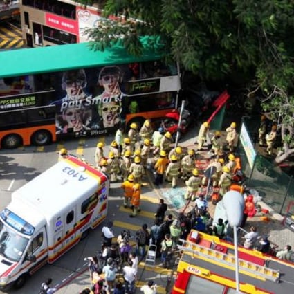 Firefighters remove the bodies from a taxi crushed between two buses. Photo: Thomas Yau