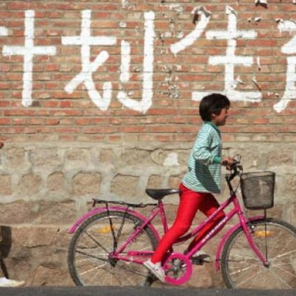 Children pass a birth control sign in China. Photo: Reuters