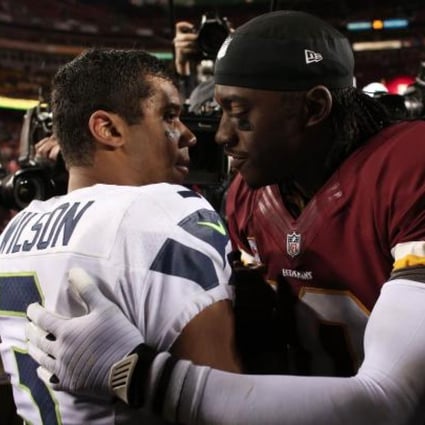 Robert Griffin III of Washington embraces Seattle's Russell Wilson after the Seahawks beat the Redskins in their play-off game. Photo: AFP