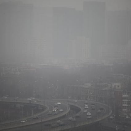 Cars run on an elevated road as buildings in the background are covered in haze, Beijing. Photo: EPA