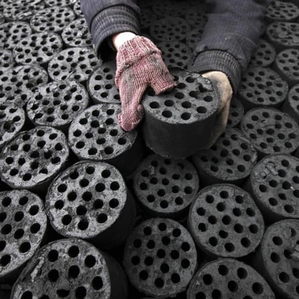 A worker collects coal briquettes in Anhui province. Photo: AFP