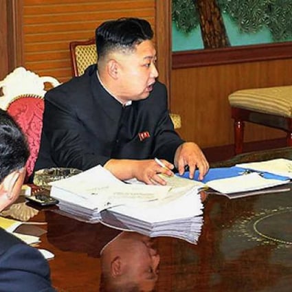 A smartphone is shown next to Kim Jong-un as he presided over a meeting with top national security advisers last week. Photo: AFP