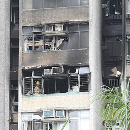 Firemen inspect the ninth-floor Cypress House flat in the Kwong Yuen housing estate in Sha Tin where a fire caused the death of a woman and injured four people early on Friday morning. Photo: Edward Wong
