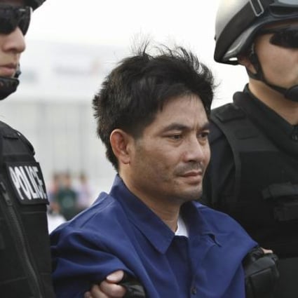 Mekong drug lord Naw Kham is restrained by two Chinese police officers. Photo: Xinhua